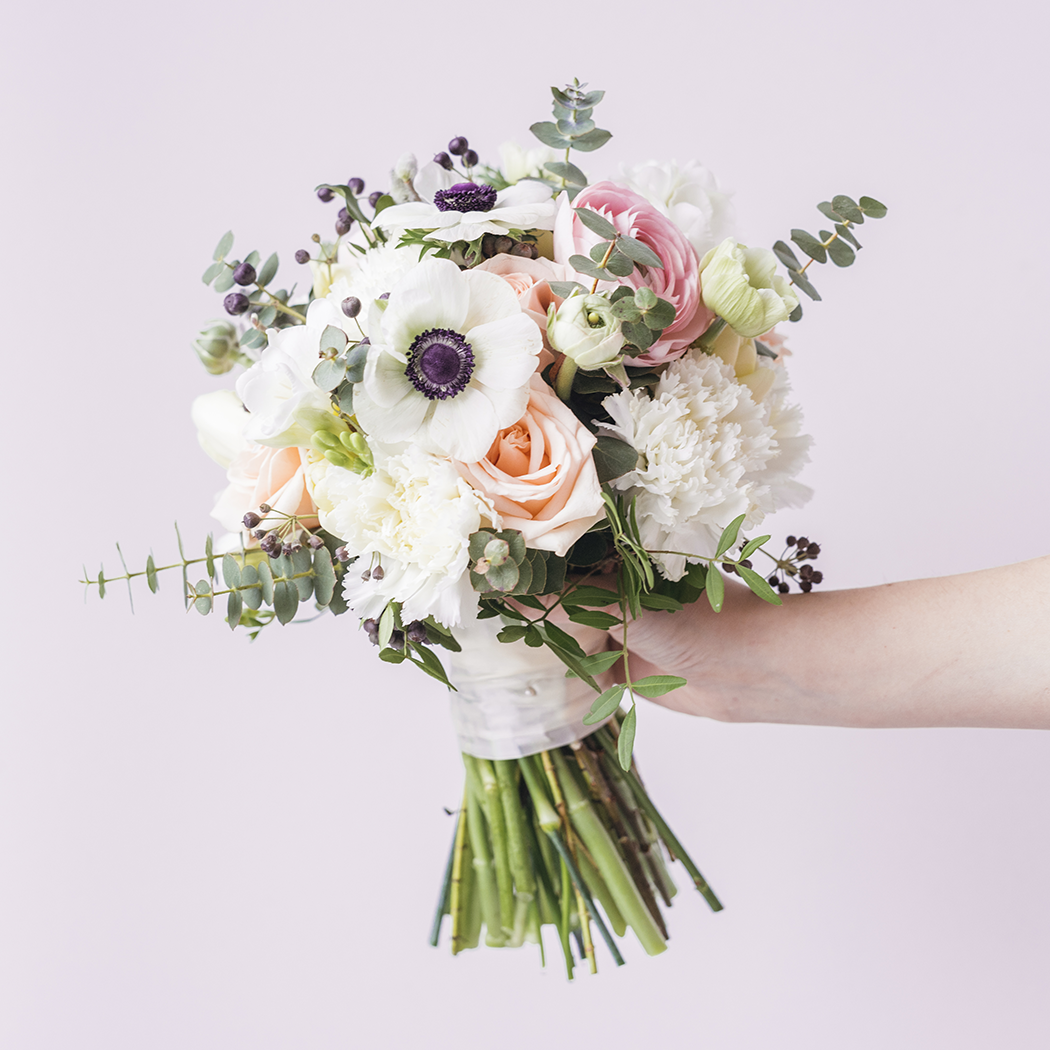 Hand holding gorgeous fresh bouquet of flowers from Inspired Flowers Florist