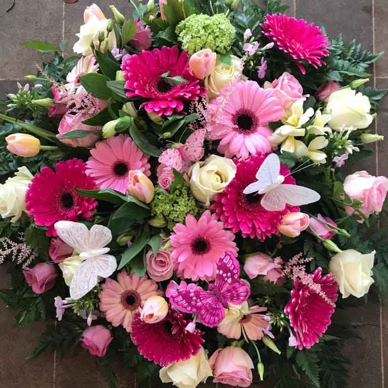 bright floral funeral tribute with butterflies